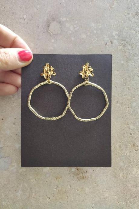 Gold brass hoop earrings, with a lobe closure in the shape of a flower